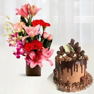 Exotic vase arrangement of red carnations, pink lilies with lavender orchids with delicious chocolate explosion cake 