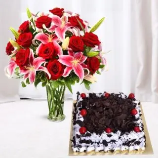Exotic vase arrangement of red roses with pink lilies with half kg black forest cool cake 