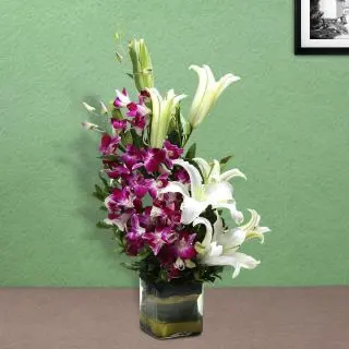 Vase Arrangement of 5 purple orchids with 3 white lilies 