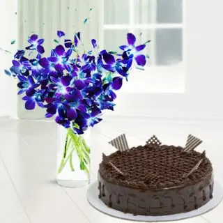 Vase arrangement of blue orchids with chocolate cake 