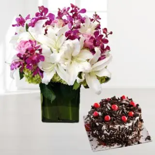 Vase arrangement of lavender orchids with white lilies with  black forest cool cake 