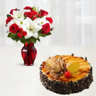 Vase arrangement of red roses with white lilies with irish chocolate cake 