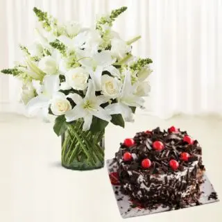 Vase arrangement of white lilies with roses , black forest cakes