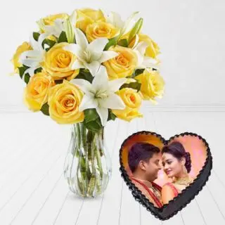 vase arrangement of yellow roses with white lilies with heart shape chocolate cakes