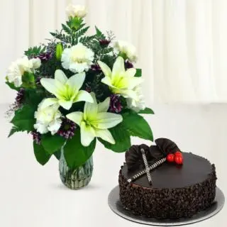 white lilies and white carnations arranged in glass vase with  choco chips cake 