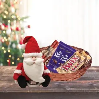 Basket Of Assorted Chocolates With Candles And Santa Clause Toys